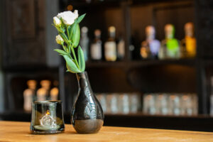 Gut Knittkuhle Bar mit Pflanze und Flaschen im Hintergrund
