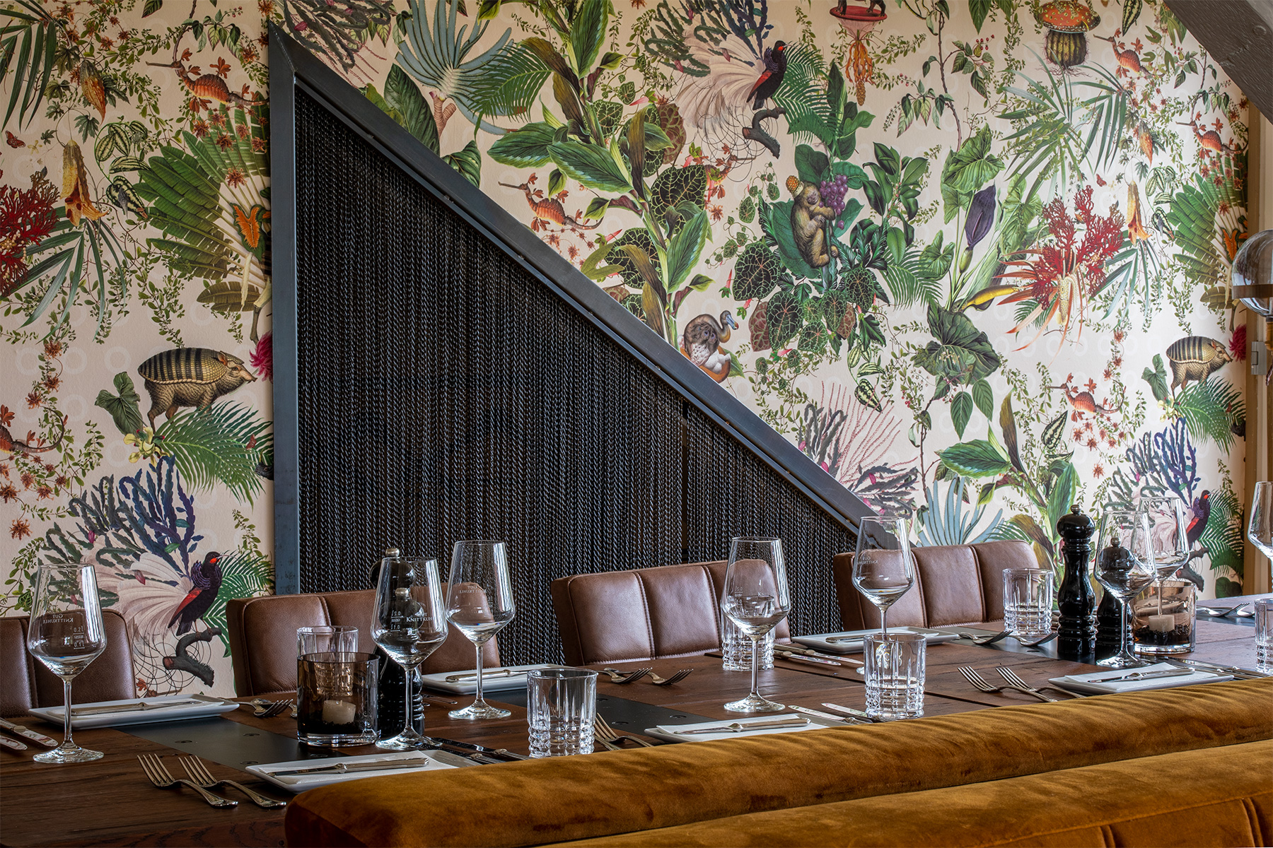 Innenbereich Gut Knittkuhl, gedeckter Tisch mit Stühlen, blumige Wand